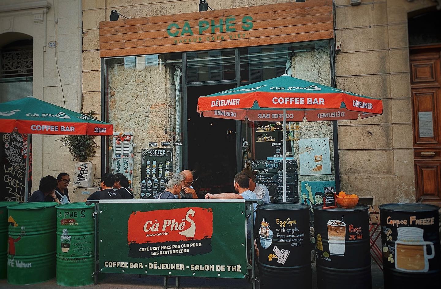 Terrasse animée et façade de Cà Phê S, rue Sainte à Marseille